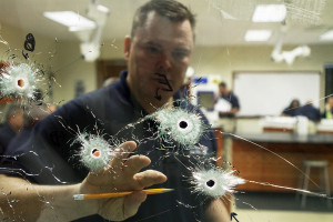 A student examines bullet holes in glass