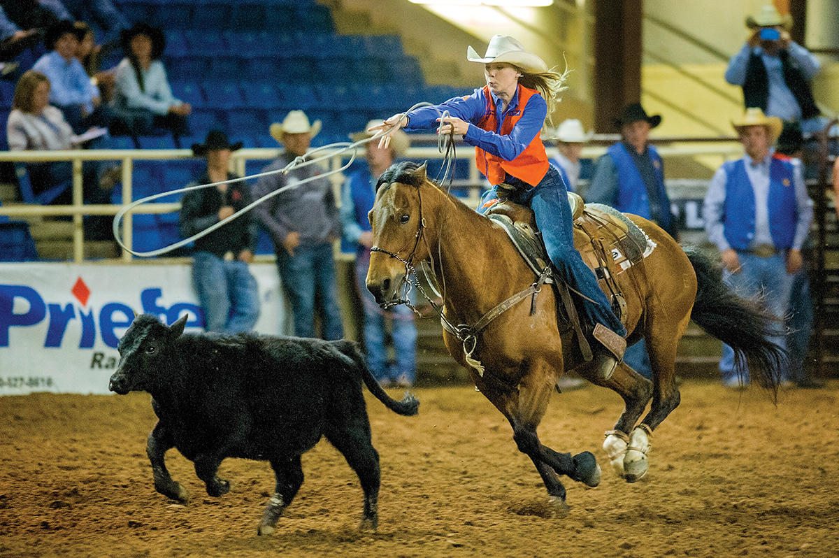 A female rodeo athlete competes in an event