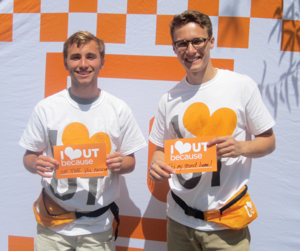 Two students hold signs 'Because of the Vol Passion', 'Because it's my second home!'