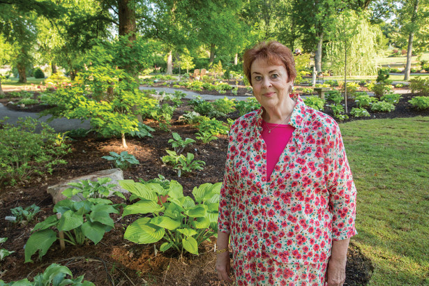 Cornelia Holland stands in front of the hosta garden