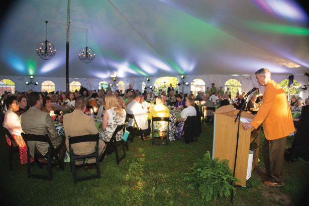 Gala attendees and speaker under a big tent
