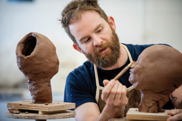 Richard W. James working on clay head sculptures