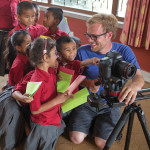 John Sellers shows his camera display to a group of schoolchildren