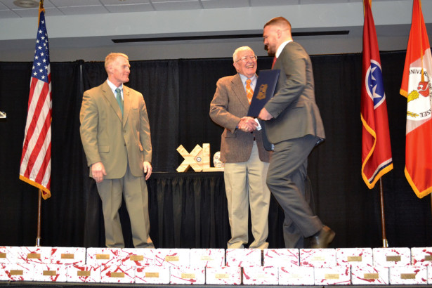 Dr. Bill Bass, center, shakes hands with TBI Special Agent Zac Burkhart, right, as UT LEIC Program Manager Jeff Lindsey, left, looks on during the NFA graduation ceremony.