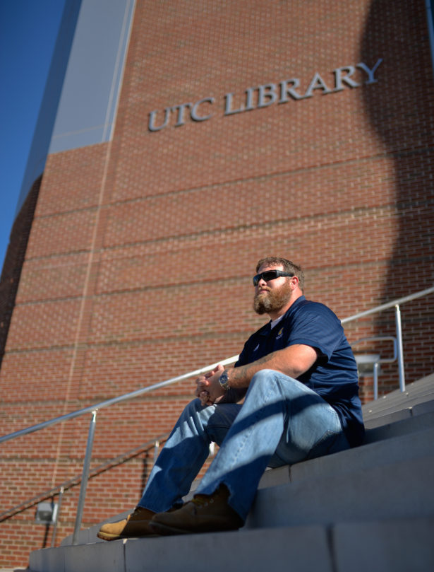 Robert Barber seated at the entrance steps to the UTC Library