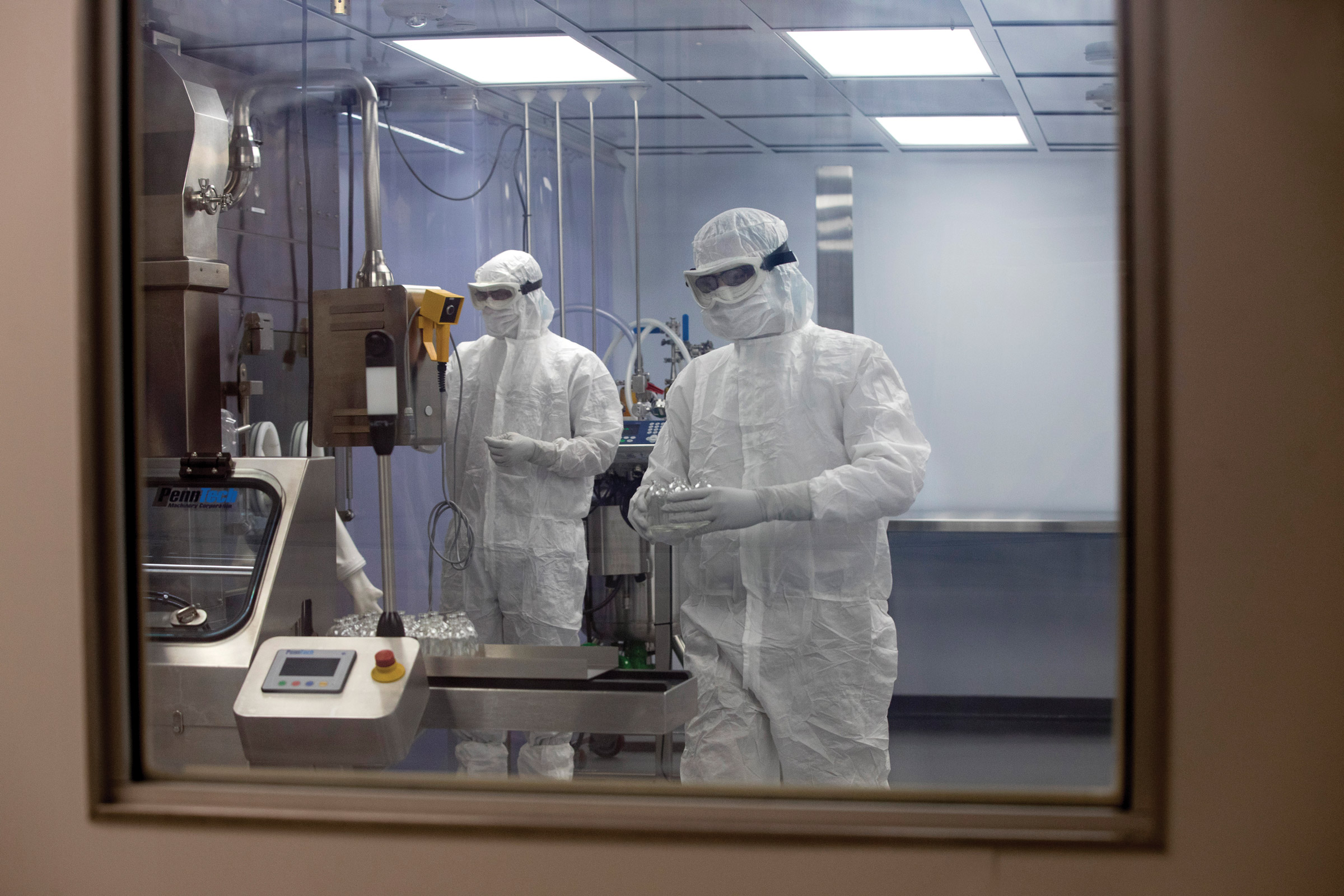 Two technicians in a cleanroom wearing protective gear