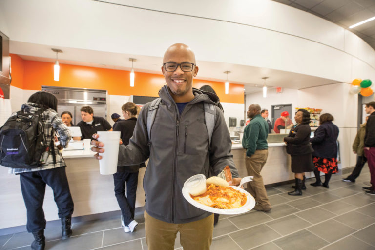 A man shows off his plate in the food court line in the revamped UTHSC facility