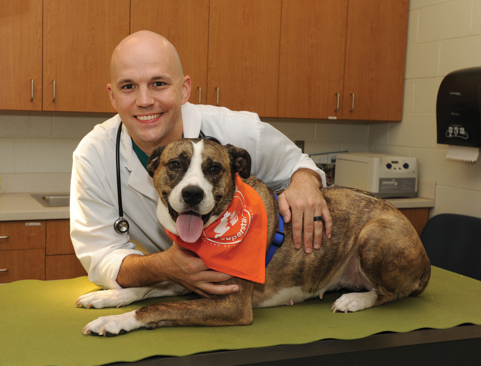 Nathan Chumbler pictured with a dog wearing a UT bandana