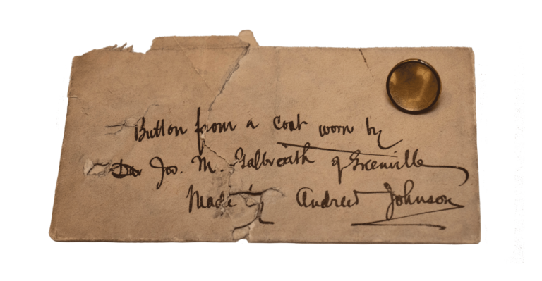 Paper with original inscription next to mother of pearl inlaid brass button