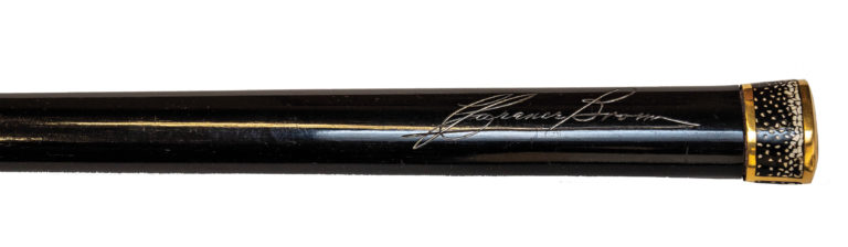 A dark cane inscribed with Clarence Brown's signature