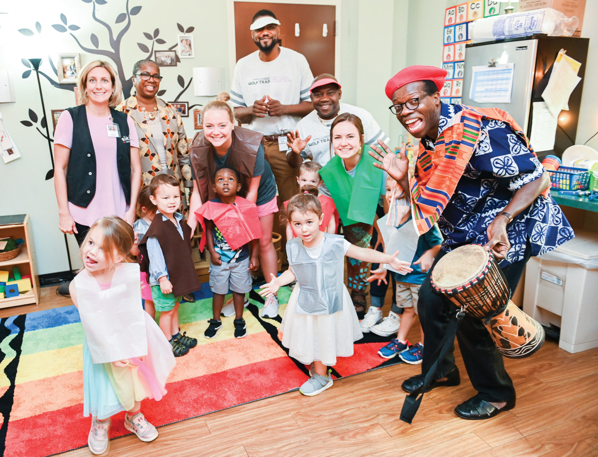 Young preschool children in costume with educators and musicians