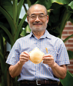 Peter Tsai holds up an orange N 95 mask