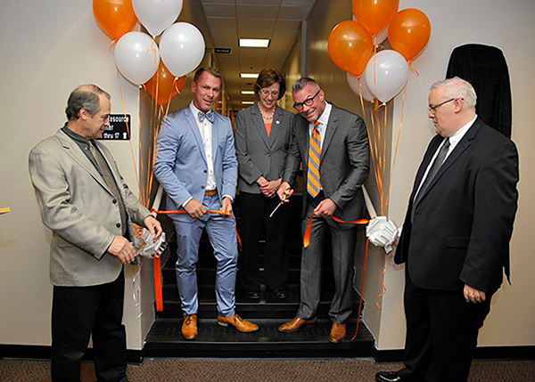 Balloons and a ribbon cutting indoors